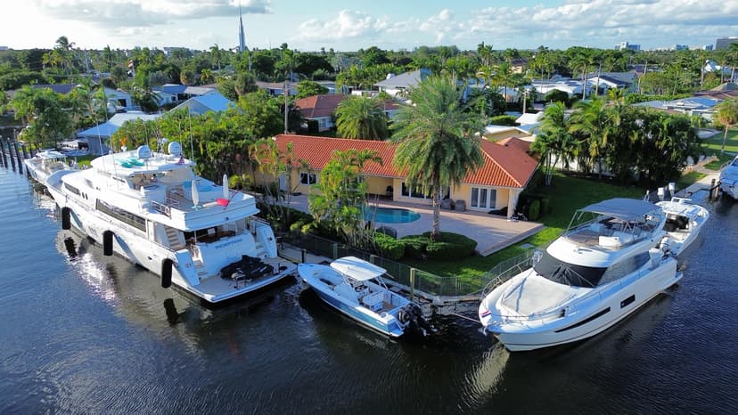 Yachts moored behind waterfront homes